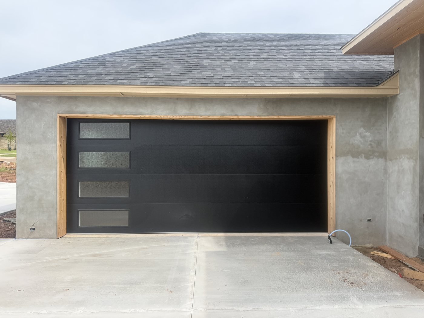 Matte black sectional garage door with four narrow vertical windows