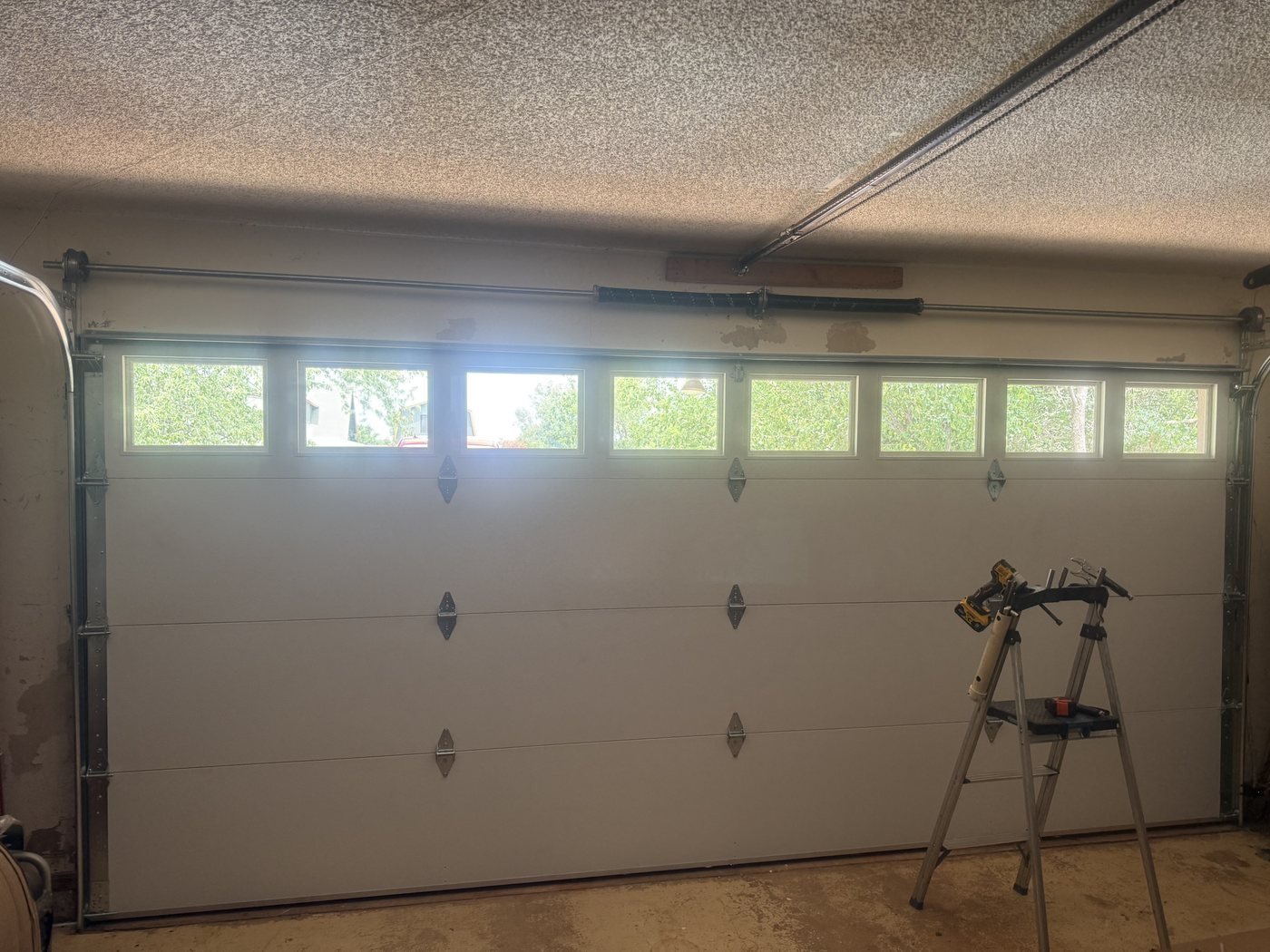 Interior sectional garage door with top windows and opener rail