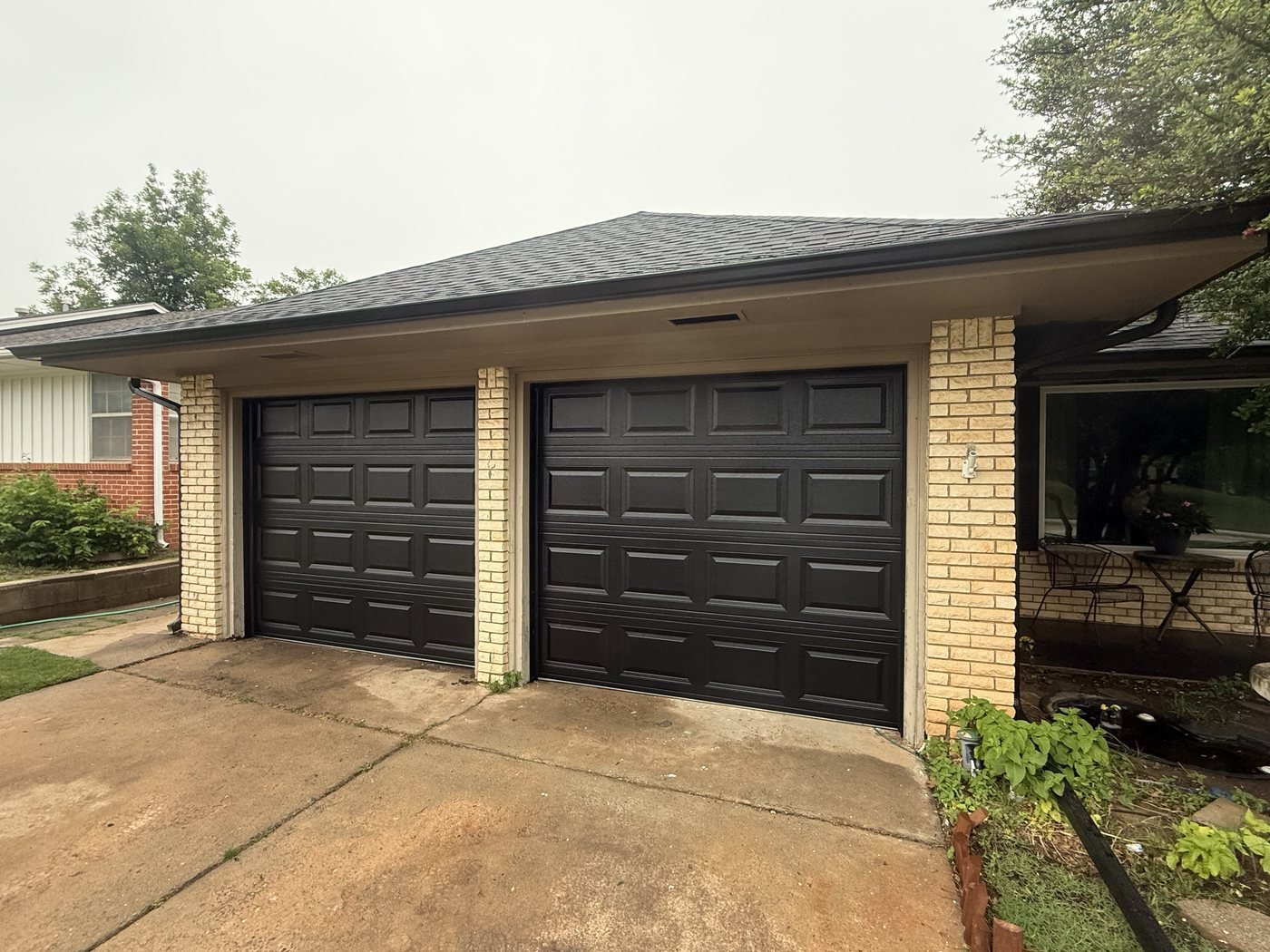 Pair of black sectional garage doors on a residential property