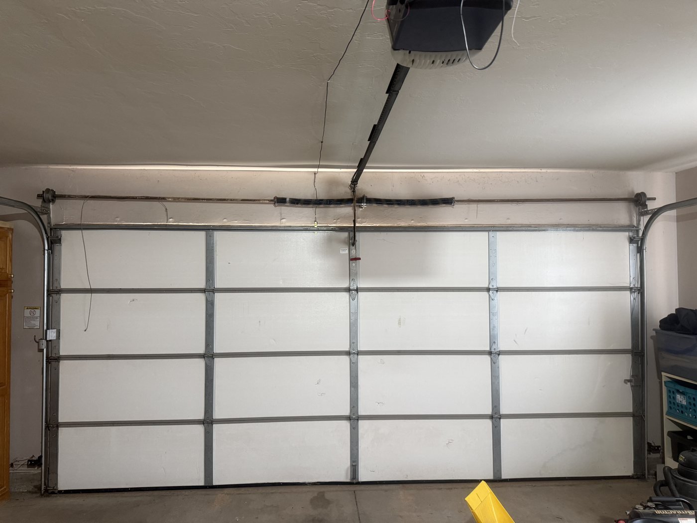 Interior view of a residential sectional door with two torsion springs above the opening